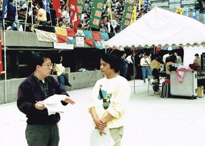 _ Akira Jinno (right), a Kyoto-based anti-apartheid activist, talks over the schedule with a fellow organizer. Jinno will serve as an interpreter for Nelson Mandela at the rally.  _ Akira Jinno (right), a Kyoto-based anti-apartheid activist, talks over the schedule with a fellow organizer. Jinno will serve as an interpreter for Nelson Mandela at the rally.