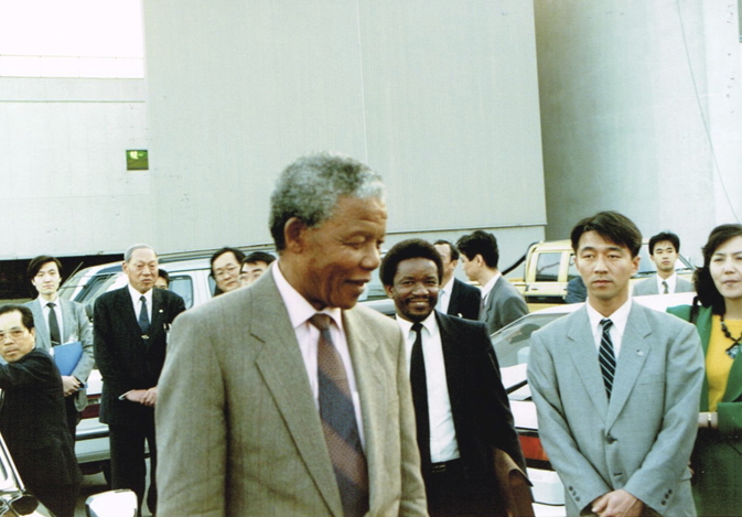 _ In true Mandela style, he suddenly breaks away from his Japanese and South African handlers and walks over to greet the anti-apartheid activists who came to welcome him.  _ In true Mandela style, he suddenly breaks away from his Japanese and South African handlers and walks over to greet the anti-apartheid activists who came to welcome him.