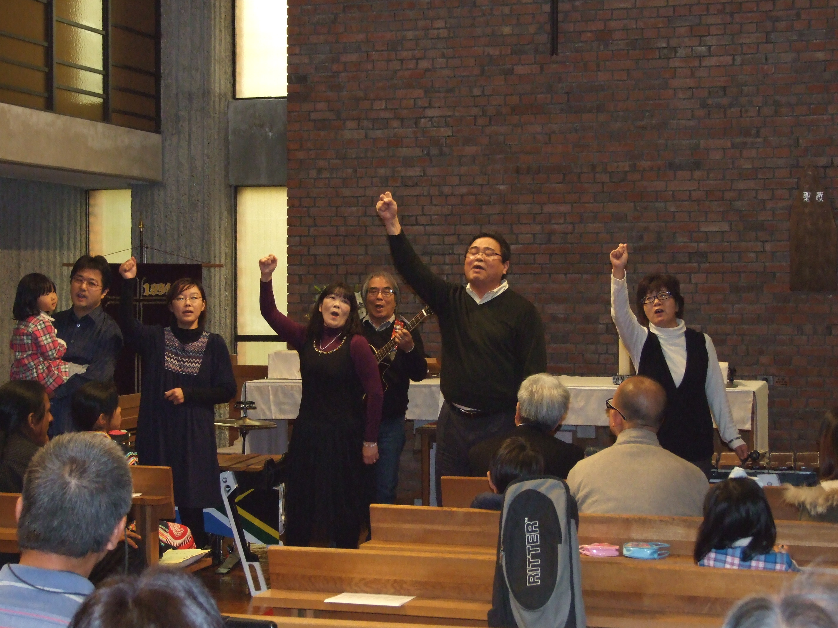 _ The choral group members raise their fists in solidarity as they sing.  _ The choral group members raise their fists in solidarity as they sing.